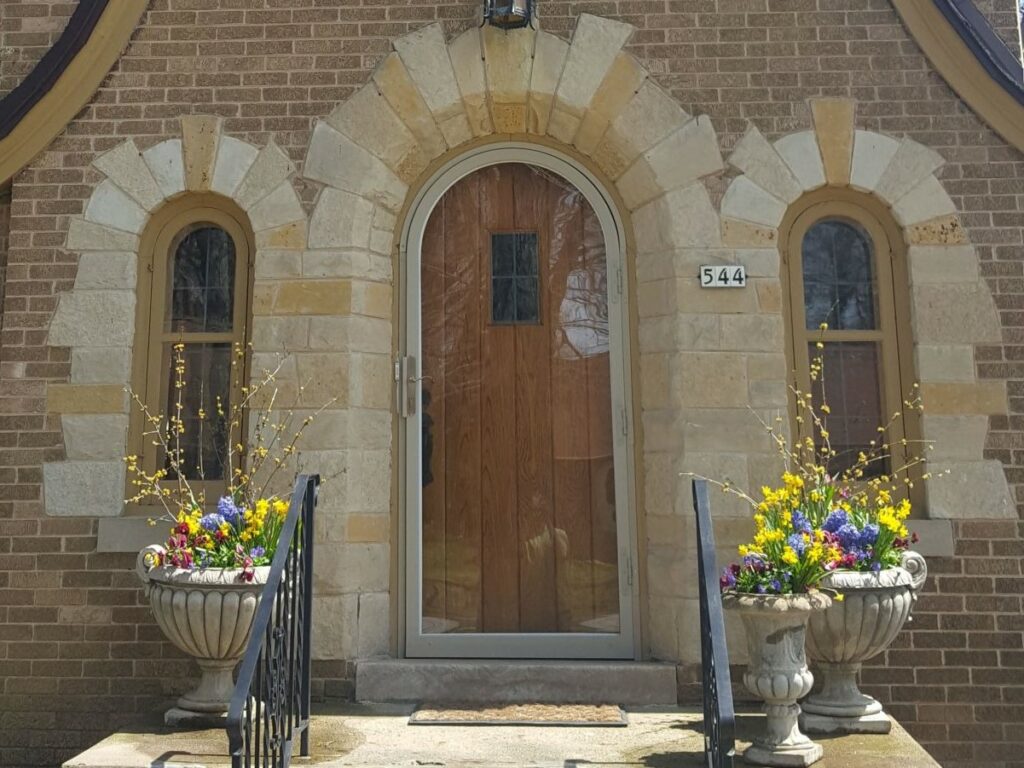 Spring bulbs and annuals container displays adorn front entrance of Wauwatosa, WI Tudor.
