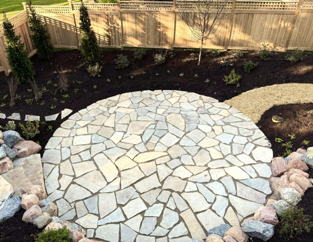 In a testimonial, a client refers to this beautiful Fond du Lac flagstone patio surrounded by new plantings and a newly seeded lawn pathway.
